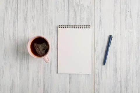 Mockup of a blank notepad, a cup of coffee and an automatic ballpoint pen Stock Photos
