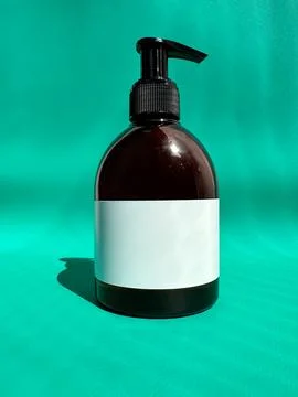 Mockup of a brown plastic bottle with a black dispenser and a white label on a Stock Photos