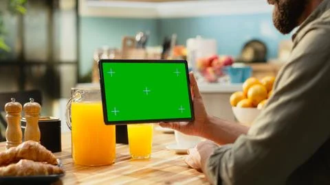 Mockup chroma key on tablet screen in the kitchen at wooden table Stock Photos