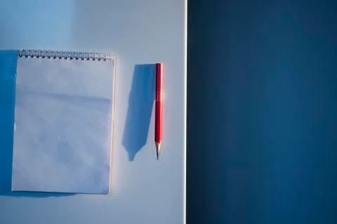 Mockup of clean white notepad with red pen or pencil on refrigerator door for Stock Photos