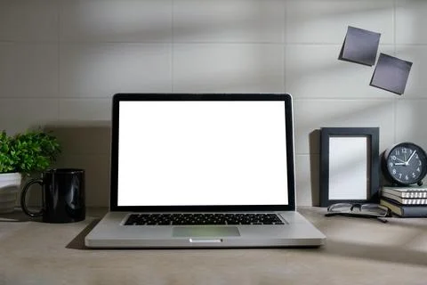 Mockup computer laptop, coffee cup, alarm clock and ceramic vase on white t.. Stock Photos