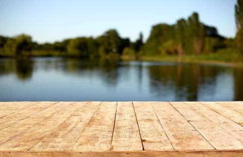 Mockup. Empty wooden deck table with foliage bokeh background. Stock Photos