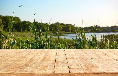 Mockup. Empty wooden deck table with foliage bokeh background. Stock Photos