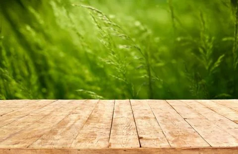 Mockup. Empty wooden deck table with foliage bokeh background. Stock Photos