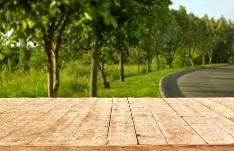 Mockup. Empty wooden deck table with foliage bokeh background. Stock Photos