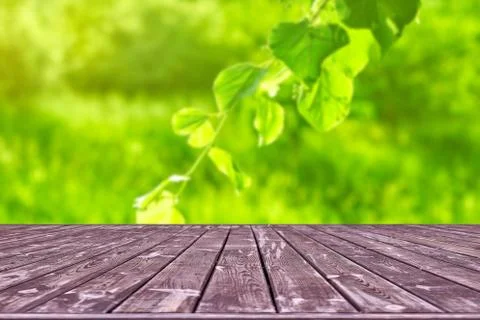 Mockup. Empty wooden deck table with foliage bokeh background. Stock Photos