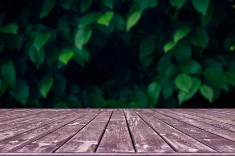Mockup. Empty wooden deck table with foliage bokeh background. Foto stock
