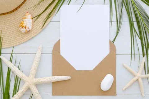 Mockup envelope with card template on white wooden background. Tropical palm Stock Photos