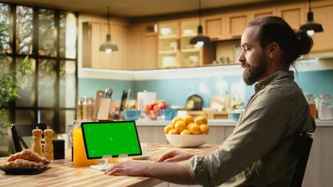 Mockup green screen on tablet screen in the kitchen at wooden table 스톡 사진