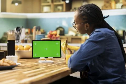 Mockup green screen on tablet screen in the kitchen at wooden table Stock Photos