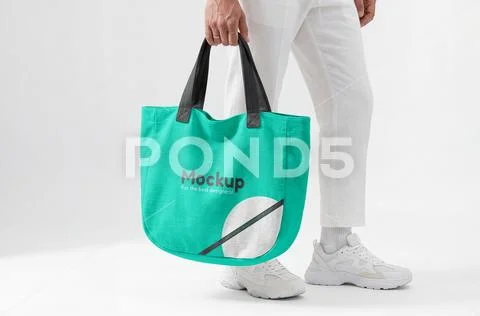 Mockup of a handle bag being held, side view Modèle PSD