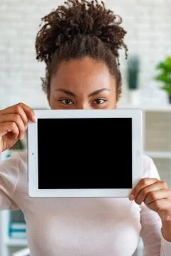 Mockup image of black empty blank screen of tablet in the female hand, peekin Photos