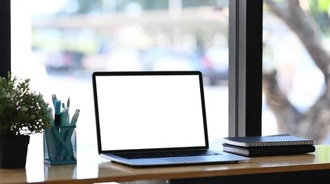 Mockup image of computer laptop, notebook, stationery and plant on white tabl Stock Photos