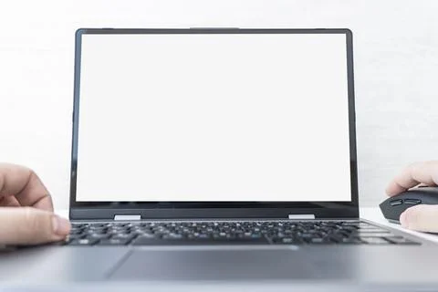 Mockup image of hands using laptop with blank white screen on table on a whit Stock Photos