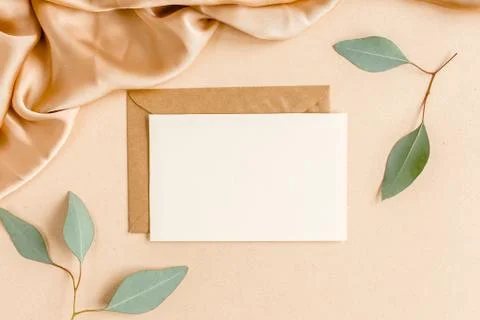Mockup invitation, blank greeting card and craft envelope, green leaves Stock Photos