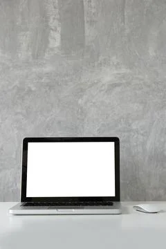 Mockup laptop computer with empty display on white table with loft wall. Stock-Fotos