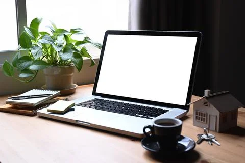 Mockup laptop computer, house model and keys on wooden table. Mortgage and real Stock Photos