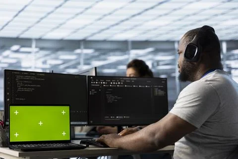 Mockup laptop in front of IT support workers coding, listening music 写真素材