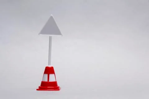 Mockup of a miniature triangular road sign on a light background. Stock Photos
