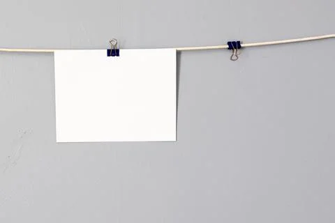Mockup of picture hanging from a string against gray wall background Stock Photos