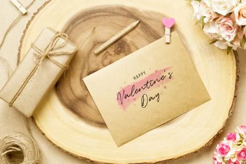 Mockup postcard and envelop on log wood with Happy Valentine's Day text, rose Stock Photos