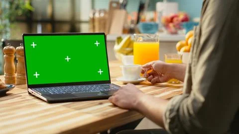 Mockup screen on laptop next to remote worker man sitting at the kitchen table 스톡 사진