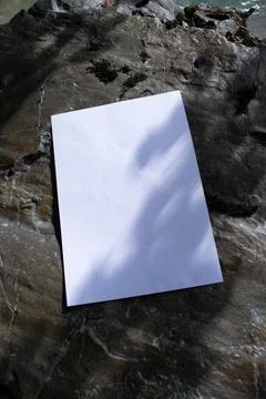Mockup of sheet with shadow on stones in diffused sunlight Foto stock