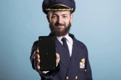 Mockup smartphone held by cheerful pilot, close up 写真素材