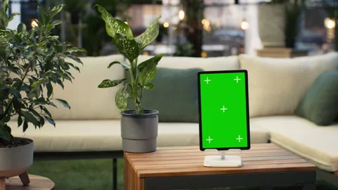 Mockup tablet with green screen on rooftop lounge table next to plant Stock Footage 345166209