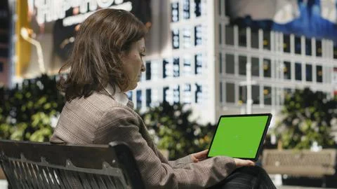 Mockup tablet used by female professional to finish work tasks in urban park Stock Photos