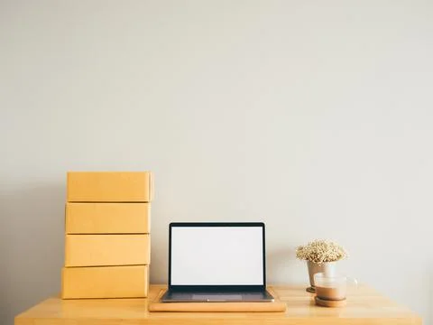 Mockup of white empty display laptop with boxes on table. Concept of online.. Stock Photos