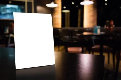 Mockup white label menu frame on table with cafe restaurant interior backgrou Stock Photos