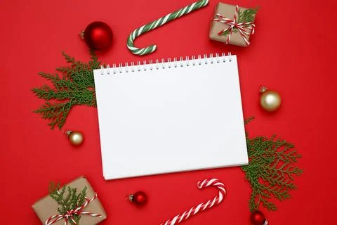 Mockup of white notebook surrounded by wrapped Christmas gifts and thuja bran Stock Photos