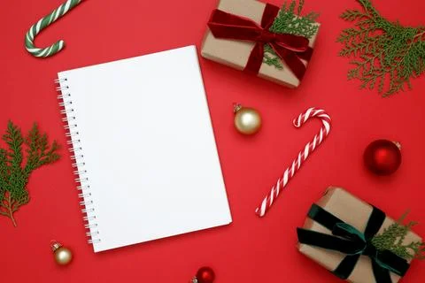 Mockup of white notebook surrounded by wrapped Christmas gifts and thuja bran Stock Photos