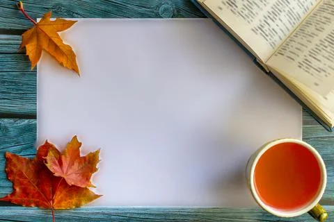 Mockup on wooden table with fall maple leaves, cup of tea and book. Autumn .. Stock Photos