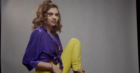 Model from the 80s is sitting on the floor and posing, retro style 4k Stock Footage 129322541