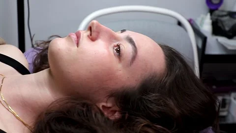 A model after cosmetic procedures in a beauty salon. A close-up of her face Stock Footage 320083959