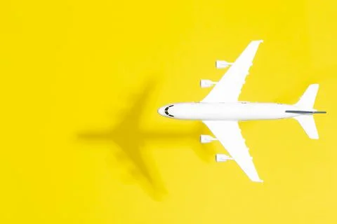 Model airplane in flight on an empty colored background. Travel minimal Stock Photos