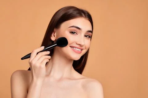 Model applying powder with make-up brush Foto stock