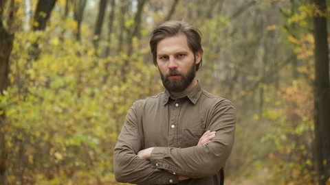 Model bearded caucasian man standing in the woods looking at camera with upset Stock Footage 143073545
