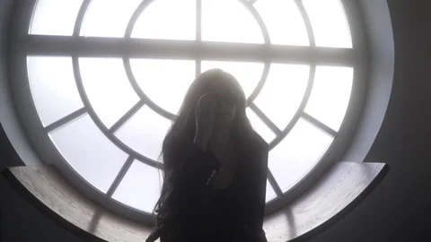 Model in black glasses sitting on the window Vidéo 261559913