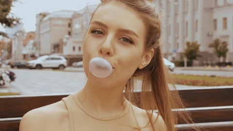 Model blowing bubble with chewing gum Stock Footage 146126215