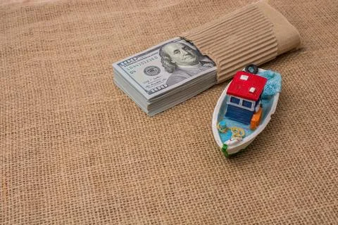 Model boat and banknote bundle of US dollar on canvas Stock Photos