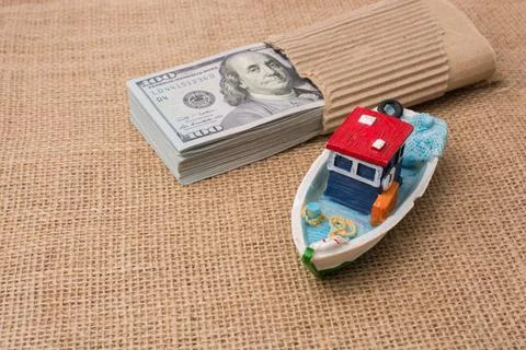 Model boat and banknote bundle of US dollar on canvas Stock Photos