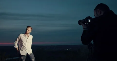 A model boy poses in front of the photographer at sunset. Slow motion. Stock Footage 145767231