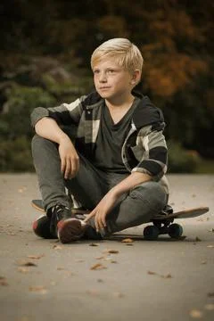 Model boy trying various poses with skate board in city park Stock Photos