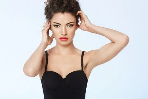 Model with bright makeup posing looking at camera. Blue background. Copy space Fotos Stock