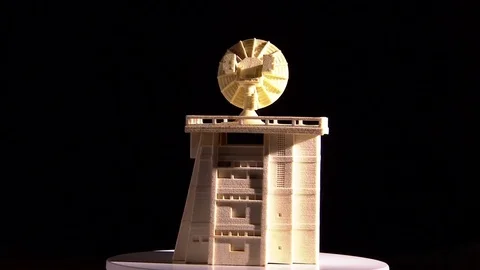 A model of a building with an antenna printed in 3D is rotating on a platform. Stock Footage 81849765