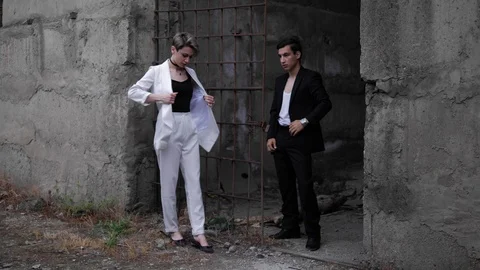 Model couple fixes dressing and poses at rusty grate Stock Footage 115252028