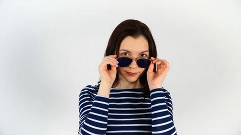 A model with dark hair, 30-35 years old, tries on sunglasses and poses on c.. Stock Footage 74722673